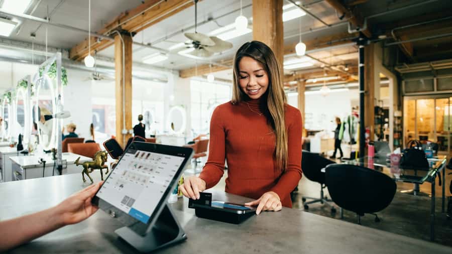 Customer paying at a bright salon checkout counter