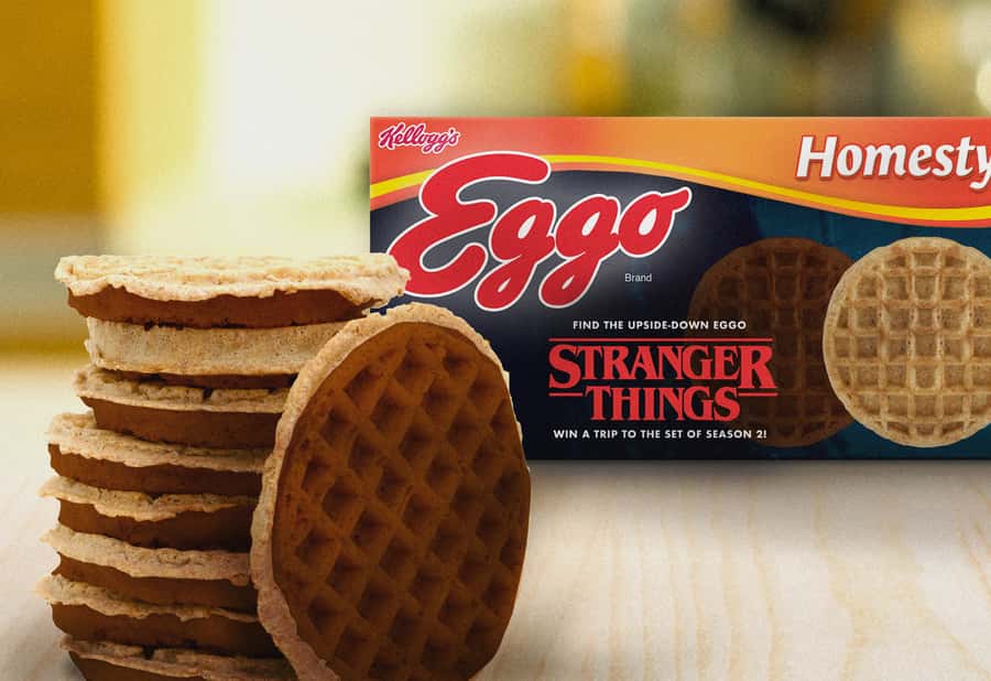 This image shows a stack of Eggo waffles and an Eggo brand box with a "Stranger Things" theme, promoting a contest for a trip to the set of the TV show.